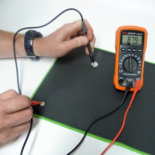 Orange Peak Meter Multimeter and probes testing conductivity of an earthing mat